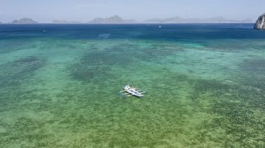 El Nido köyü yakınlarındaki sığ lagün koyuna demirlemiş Filipinli gemilerin hava görüntüsü. Bacuit Körfezi, Palawan, Filipinler