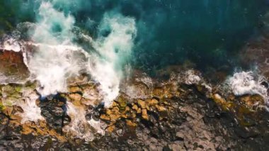 Uçağı Tenerife Cennet Adası 'ndaki yaban kayalıkları üzerinden uçuracak. Dalgalar taşların ve kayaların üzerinde kırılıyor, köpük. Su zümrüttür, koyu mavi ve yeşil. Turkuaz okyanusun güzel manzarası.