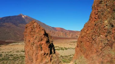 İspanya 'nın Tenerife Kanarya Adaları' ndaki volkanik kaya oluşumları ve volkan Teide ile çöl manzarası. Uçuşlar uçurumlarda.