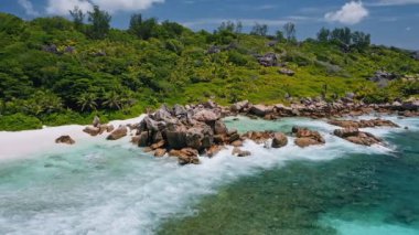Anse Coco 'nun tropik cennet plajındaki göl dalgalarının ve devasa granit kayaların hava dairesi görüntüleri. Seyşeller 'deki La Digue Adası