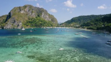 Corong Corong plajı, El Nido, Palawan adası, Filipinler- Zümrüt yeşili su lagünüyle körfezde demirlemiş teknelerin hava aracı görüntüsü