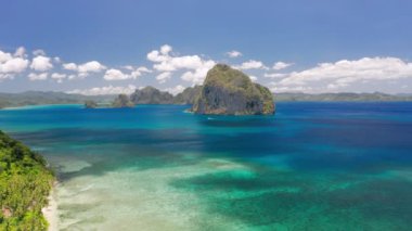 Las Cabanas sahilinin açık denizindeki kayalık Pinagbuyutan adasının insansız hava aracı görüntüsü. El Nido, Palawan, Filipinler. Yaz ve seyahat tatil konsepti