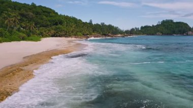 Mahe Adası, Seyşeller. Okyanus dalgalarının kumlu tropik plajlara inişi.
