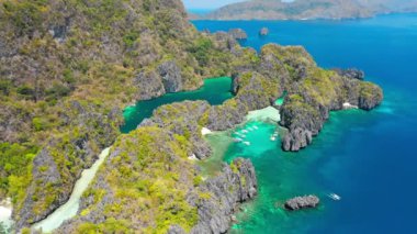 Miniloc Adası 'ndaki küçük ve büyük göl manzarası. El-Nido, Palawan. Filipinler. A turunda bitkilerle ve mavi sığ koylarla kaplı kireçtaşı kaya oluşumu..