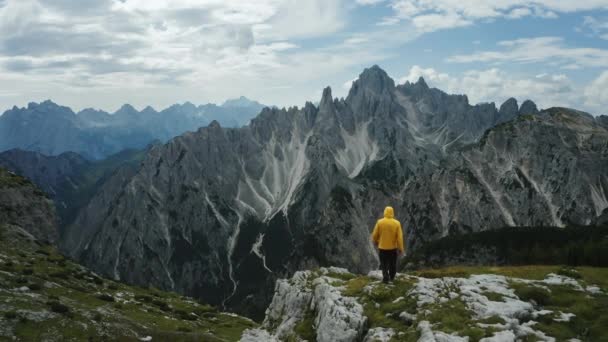 ドロミテス イタリアのカドミナ ミスリナ山脈群のオーロニーゾ カドールの前で黄色いコートの男性の空想的な眺め トレイ レバレド国立公園とユネスコの世界遺産の一部 — ストック動画