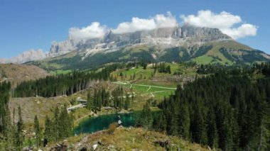 Carezza Gölü 'ndeki güçlü rüzgârdan sonra köklerinden sökülmüş çam ağaçlarını gören yetişkin kadınlar. Güney Tyrol' daki en güzel göller, Dolomitler..