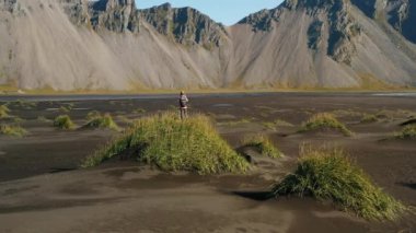 Stokksnes 'deki destansı manzara. Dune 'daki kadın turist, Vestrahorn dağına bakıyor. İzlanda doğası.