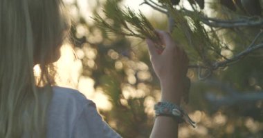 Gün batımına karşı aşırı yaklaşan kadın parlak güneş parıltılarına karşı. Kadın akşam güneşinin tadını çıkarıyor. Arka planda bulanık bokeh güneş parıltısı yansıdı. Tatil Tatil Zamanı