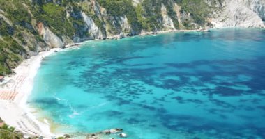 Kefalonia 'nın batı kıyısındaki güzel Petani Sahili' nin panoramik manzarası yaz mevsiminde zümrüt yeşili deniz, Yunanistan.