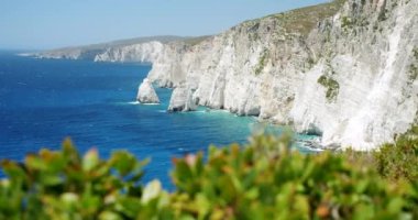 Zakynthos adası ve İyon Denizi 'nin güzel beyaz uçurum kıyıları. Önplanda yeşil yaprak.