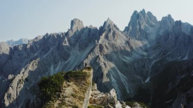 İtalya 'nın Dolomites kentindeki Cadini di Misurina dağlarının önündeki kaya tepelerindeki kadınlar. Hava aracı yörünge görüntüsü. Tre Cime di Levaredo Ulusal Parkı ve UNESCO Dünya Mirası Alanı.