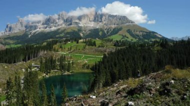 Carezza Gölü 'ndeki güçlü rüzgârdan sonra köklerinden sökülmüş çam ağaçlarıyla ormanın önündeki kız. Güney Tyrol' daki en güzel göller, Dolomitler..