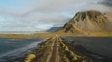 Yaz sabahı Vestrahorn Dağı 'na yakın bir yolda uçarken Stoksnes, İzlanda. İHA 'dan hava görüntüsü.