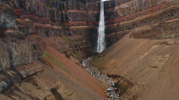 ヘンギフォス滝 赤い山の壁とアイスランドの川の空中静的な映像 — ストック動画