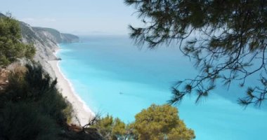 Yunanistan 'ın Lefkada adasındaki Egremni plajı yakınlarındaki turkuaz mavi deniz lagünündeki yalnız yelkenli teknesi..