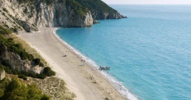 Milos plajı yaz ışığı altında, Lefkas, Yunanistan. Teknelere atla, turistleri al..