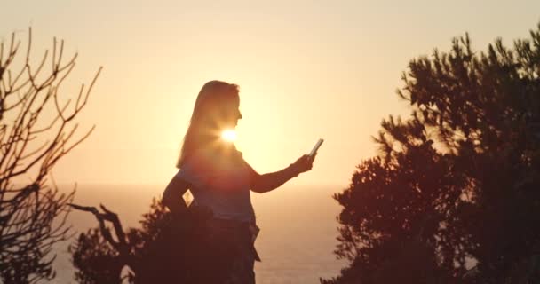 Woman Holding Phone Makes Selfie Photo Sunset Time Sea Background — Stock Video