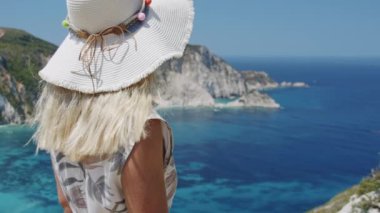 Dağın tepesindeki kadın gezgin deniz koyuna bakıyor tatil macerası manzarasını kutluyor doğa.