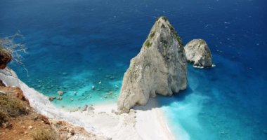 Akdeniz kıyısı, büyük beyaz kayalık oluşumu, uzak sahillerde mavi deniz ve turistik zevk tekneleri. Üst görünüm.