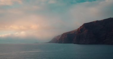Los Gigantes 'in Tenerife İspanya kayalıklarında gün batımında sakin dalgalarla okyanus karanlık suları. Rahatlatıcı deniz manzarası.