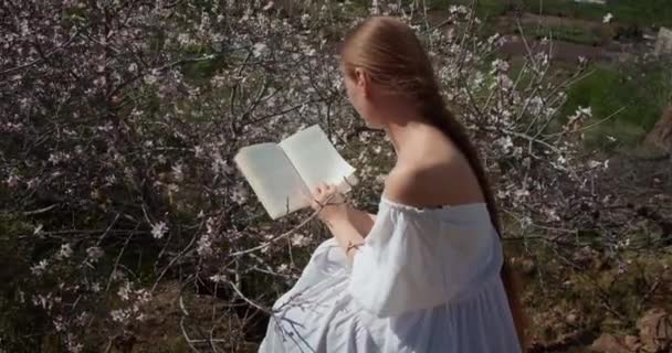 Adolescente Sentada Natureza Selvagem Ler Livro Visão Traseira Mulher Jovem — Vídeo de Stock