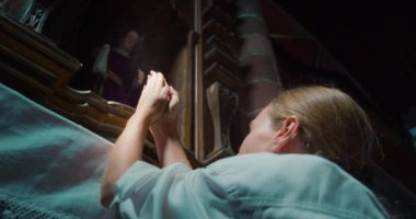 Genç kız kilisede diz çöküp Tanrı 'ya el kaldırıyor. Umut kavramı. Ağır çekimde yakın çekim. Dindar bir kadın..