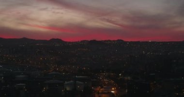 Gece parlayan Santa Cruz de Tenerife şehri, parlak kırmızı günbatımı gökyüzü. Kanarya Adaları, İspanya. Torres 'in ikiz kulelerinden görüntü.