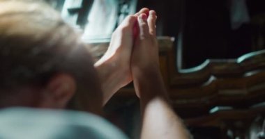 Kilisenin karanlık bir köşesinde Tanrı 'ya dua eden bir kadın. Kurtarıcı İsa 'ya dua etmek için katlanmış eller. Hıristiyanlık dini kavram.