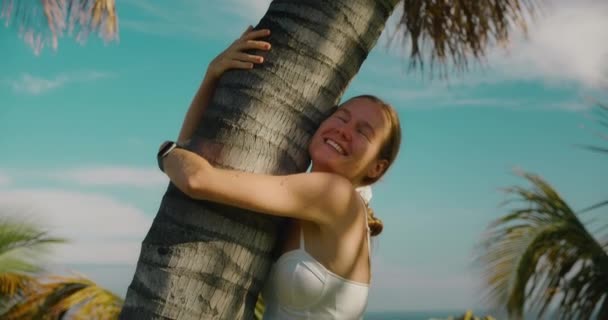 在热带森林里 年轻快乐的女人抱着棕榈树 充满柔情和爱心 女孩摸树干特写 抚摸树皮 人类与自然的统一 特写慢动作电影 — 图库视频影像