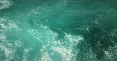 Fırtınada okyanus suyu arka planında. Mavi akuamarin deniz dalgaları rüzgarda sallanıyor..