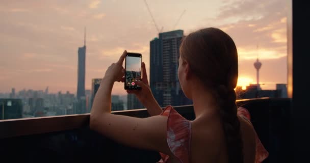 Приваблива Брюнетка Тримає Телефон Руках Фотографує Вечірнє Місто Відкритому Повітрі — стокове відео