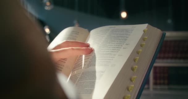 Χέρια Κρατούν Ένα Ανοιχτό Βιβλίο Αγία Γραφή Στη Βιβλιοθήκη Του — Αρχείο Βίντεο