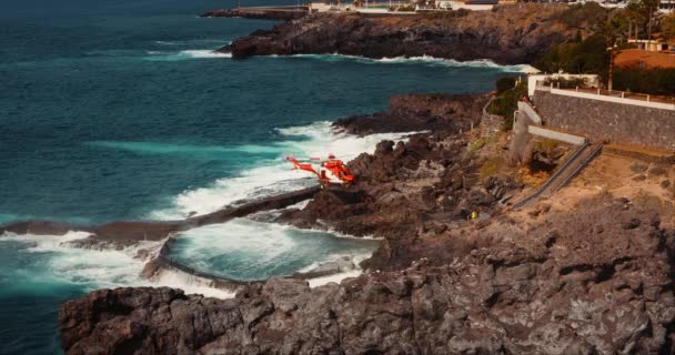 Hélicoptère Médical Atterrissant Sur Côte Volcanique Rocheuse Pour Une Opération — Video