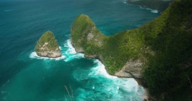 Kelingking kumlu plajı, uzun kayalık kayalıklar ve turkuaz okyanus Nusa Penida Adası Bali. 4k yavaş çekim yakın çekim.