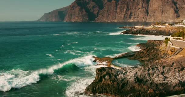 海岸線の崖や海の景色カナリア諸島のテネリフェ島のAcantilados Los Gigantes 動きの遅い海の波が晴れた日に岩の多い海岸に飛び散る — ストック動画