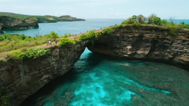 位于巴厘岛努沙佩尼达岛上的热带不寻常的海滨破碎海滩 印尼东南亚最受欢迎的旅游目的地 有孔洞的天然桥梁的空中景观 — 图库视频影像
