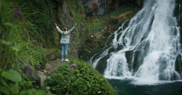 Жінка Подорожує Водоспаду Високогір Піднімає Руки Насолоджується Природою Життям Подорожі — стокове відео