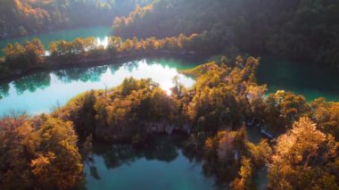 Dağ gölü ve sık orman manzarası sonbahar güneşli sabahında. Rezervuardaki temiz turkuaz suyu. Plitvice Lakes Ulusal Parkı Hırvatistan.