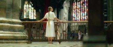 Avrupa 'daki katedral kilisesinde gezintiye çıkmış bir kadın. Uzun elbiseli, örgülü saçlı, mimariye bakan yetişkin bir kız.