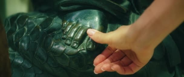 女孩的手抚摩着圣殉道者的雕塑以祈求好运 敬拜者用她的手抚摩一只光滑的青铜脚 电影手牵手特写 — 图库视频影像