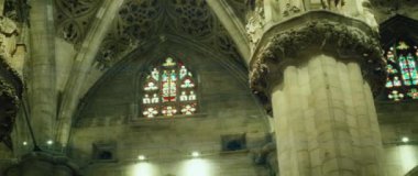 Tarihi bir müzede, alçılı, heykelli ve uzun kavisli camlı pencereli güçlü sütunlar. Klasik sinematik yakın çekim görüntüsü. Antik Katedral Bazilikası.