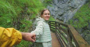 Mutlu kadın, erkeğin elini tutuyor dağlarda dar patikada yürürken ona bakıyor. Beni takip et. Sevgili çift Avusturya 'da Dark Gorge' da romantik bir gece geçiriyor. Seyahat, turizm