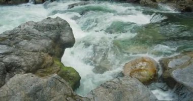Güçlü su akıntısı kayaların üzerinde çok hızlı hareket eder. Öfkeli beyaz su dağı nehir akıntısı. Kristal berraklığında bahar akıntıları