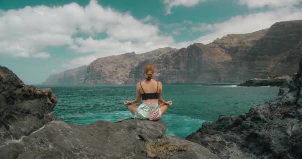 Mujer Medita Posición Loto Costa Rocosa Por Océano Chica Respirando — Vídeos de Stock