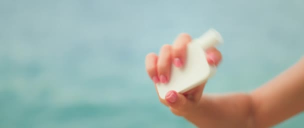 矿物防晒霜氧化锌在使用前要摇匀 女孩手拿着白色的护肤霜管 放在大海的水底 女性在镜头前展示化妆品 — 图库视频影像