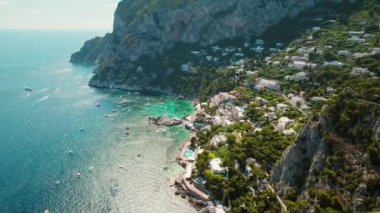 İtalya 'nın engebeli kıyı şeridi ve gök mavisi rengi Tyrhenian Denizi ile Capri Adası' nın göz kamaştırıcı hava manzarası. Uzakta Faraglioni yığını..