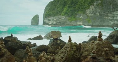 Şiddetli dalgalarla okyanus çarpışabilir Nusa Penida 'nın kireç taşı kayalıklarıyla havaya karışabilir. Tembeling Plajı ve Ormanı, Bali, Endonezya.