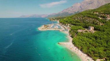 Turkuaz Adriyatik manzarası. Yukarıdan bakıldığında nefes kesen Makarska Riviera, Hırvatistan 'ın turkuaz suları, çakıllı kıyıları ve dağlık bir zemin üzerindeki yemyeşil alanları turistleri davet ediyor.