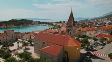 Tarihi binaları olan Makarska kasabası. Hırvatistan 'da antik kilise ve kırmızı kiremitli çatılar, derin mavi Adriyatik Denizi manzarası.