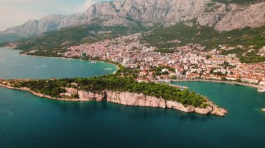 Yukarıdan Makarska kıyı şeridi. Serin deniz suları, yemyeşil ve dağ sıraları tarafından çerçevelenmiş kayalık kıyıları öper, sakin keşifler..